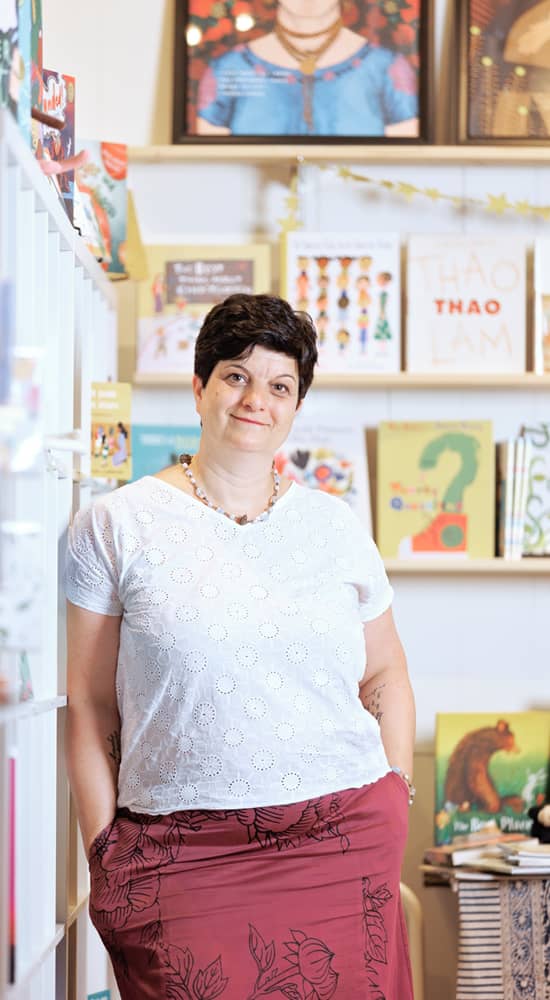 Anne, owner of Kinder Books standing in her store.